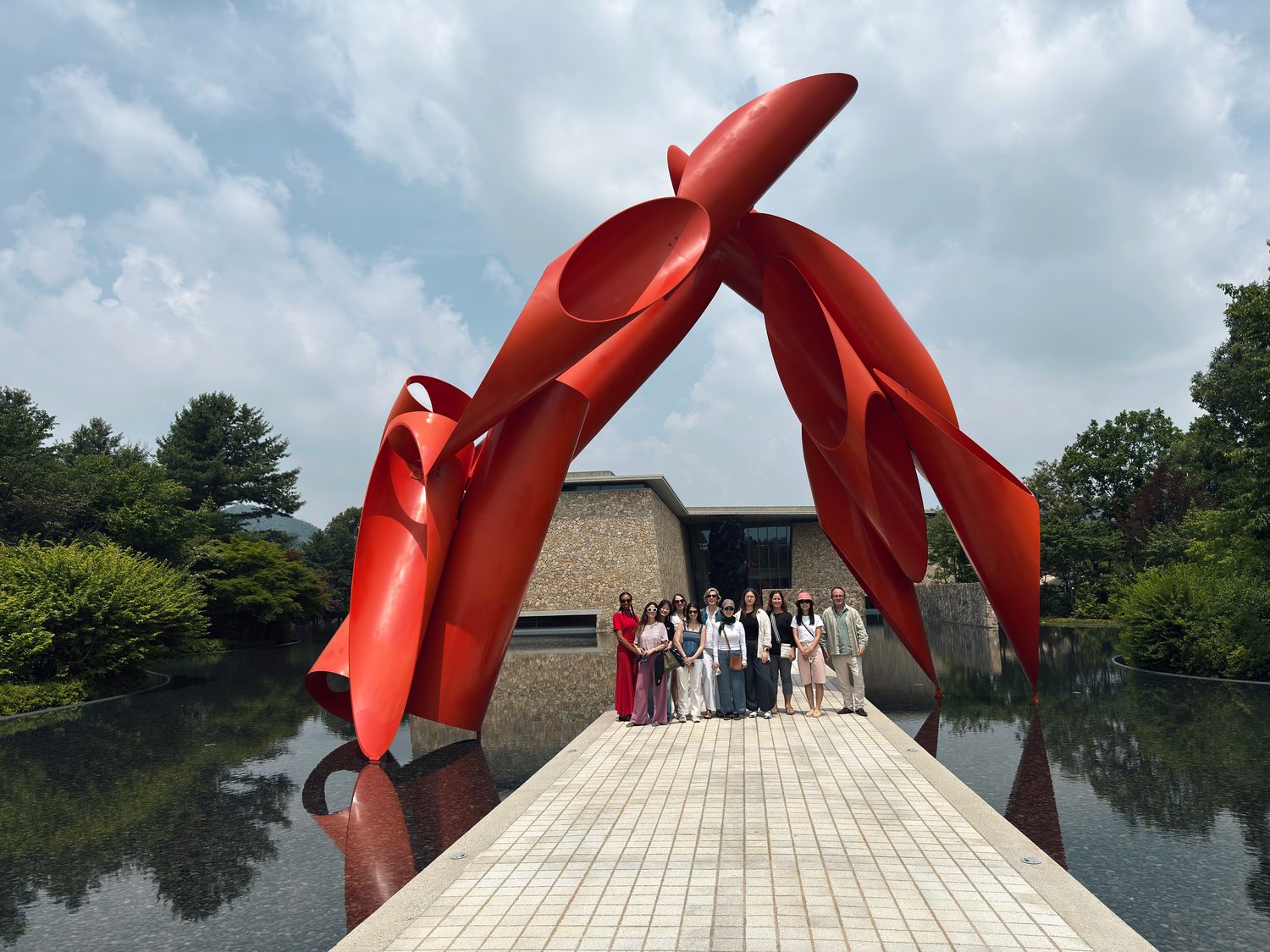 The group beneath a vermilion sculpture