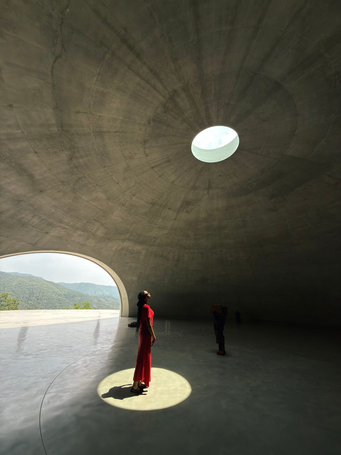 A figure in red beneath the oculus at Museum SAN